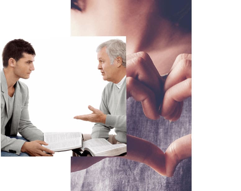 Two men are sitting at a table and one is holding something up to the other.